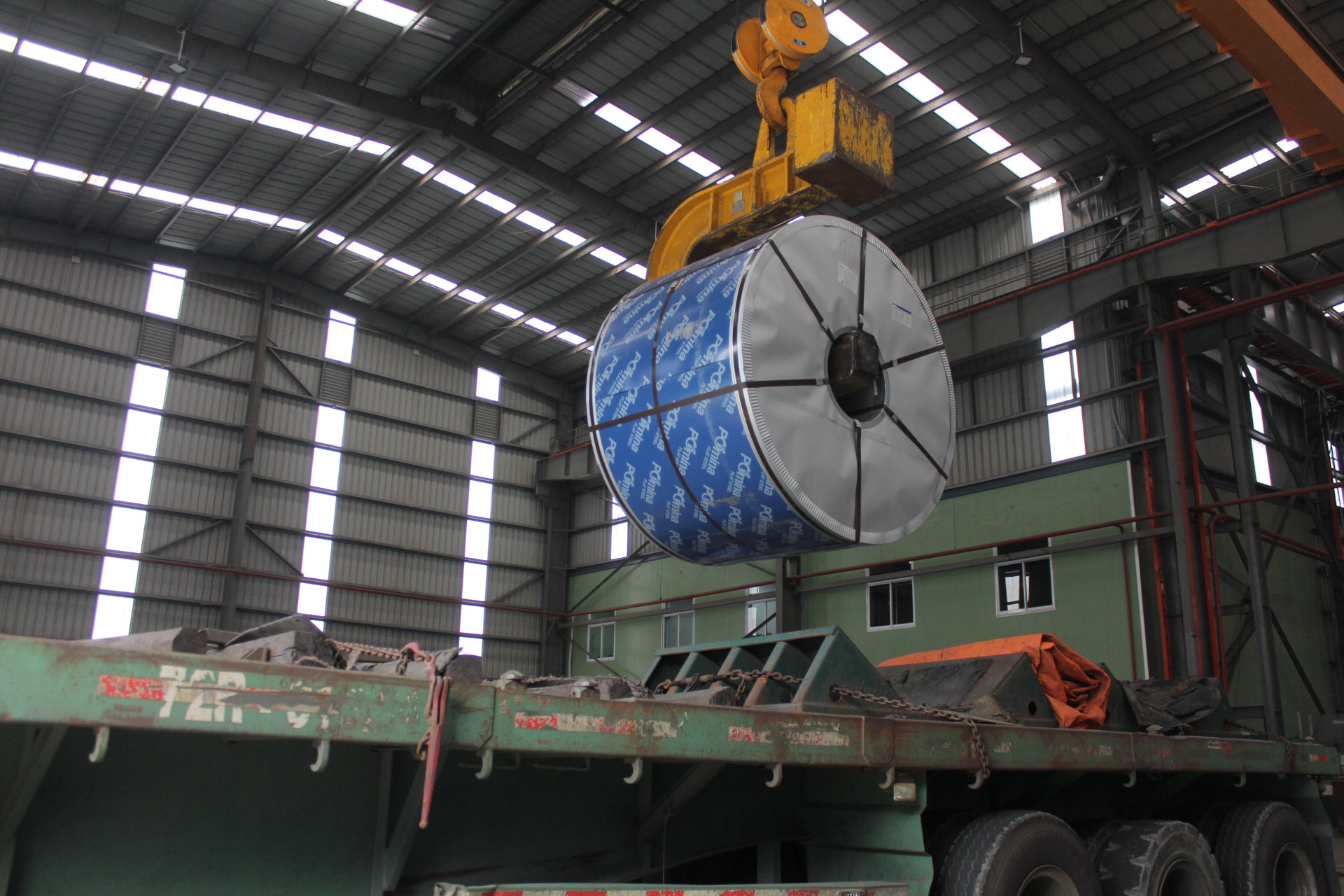 Hình ảnh cuộn tôn mạ lạnh được cẩu lên xe chuyên chở hàng tại kho xuất khẩu nhà máy Tôn Pomina
